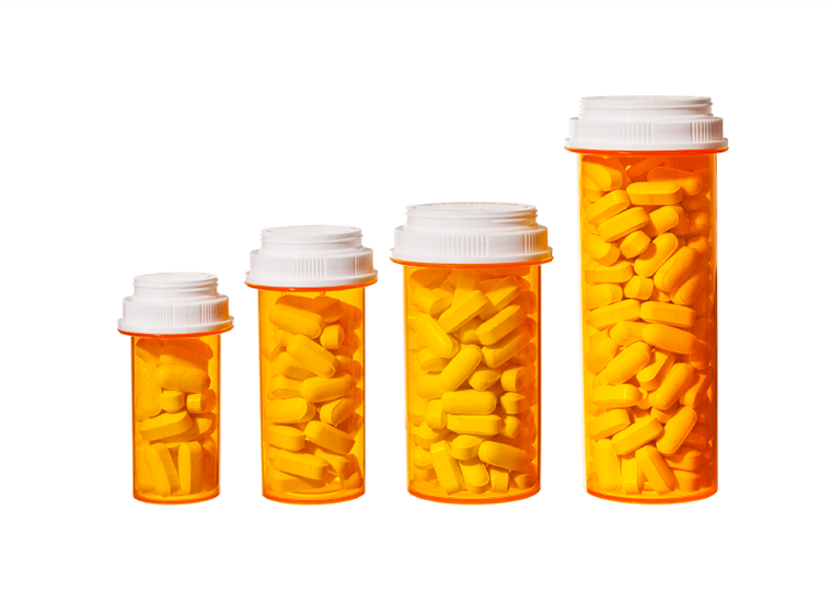 Bottles of pills arranged to represent a bar graph showing the rising cost of medicine.